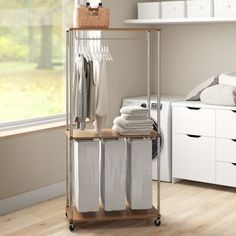 an organized closet with clothes and linens on the shelves, in front of a window