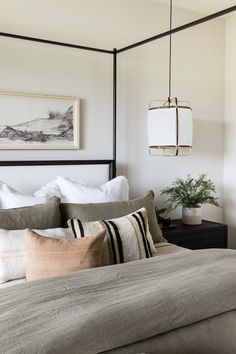 a bed with white sheets and pillows in a bedroom