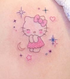 a hello kitty tattoo on the back of a woman's stomach, with stars and moon