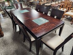 a table and chairs in a room filled with wooden tables, chairs and other furniture