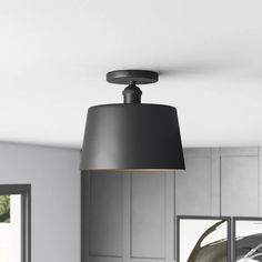 a black lamp hanging from the ceiling in a kitchen