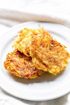 two fritters on a white plate with a napkin in the backgroud