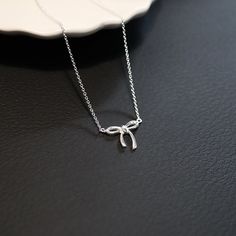 Add a sweet touch to your jewelry collection with our Small Bow Necklace. Delicate and stylish, this necklace is the perfect for everyday wear or special occasions, effortlessly enhancing any outfit. * Design: Features a dainty bow, symbolizing elegance and playfulness. * Material: High-quality 925 Sterling silver. * Size: 1 mm Thick Cable Chain, Bow: 12x15 mm * Chain Length: 40cm + 4cm * Matching Bow Earrings: https://liorajewelryhouse.etsy.com/listing/1659586743 * Complimentary Gift Wrapping * Elegant Charm Necklaces With Clavicle Chain As Gift, Elegant Round Charm Necklaces For Gifts, Elegant Round Charm Necklaces, Sterling Silver Clavicle Chain Necklace Suitable For Gifting, Dainty Sterling Silver Charm Necklace Gift, Dainty Sterling Silver Charm Necklace For Gift-giving, Dainty Sterling Silver Charm Necklace For Gift-giving Occasion, Sterling Silver Pendant Charm Necklace As Gift, Sterling Silver Clavicle Chain Charm Necklace For Formal Occasions