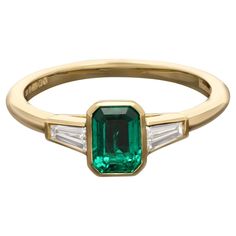 A beautiful emerald and diamond ring by Hancocks, centred on a lovely rich and deeply saturated emerald-cut emerald of Colombian origin weighing 0.68cts rub over set in yellow gold between elegant tapered baguette cut diamond shoulders also in rub over settings to a simple D-shape shank, all handmade in 18ct gold. Maker Hancocks Period Contemporary Origin London Gemstones 0.68ct emerald-cut Colombian emerald with GCS certificate 2 x tapered baguette cut diamonds weighing 0.23cts in total Setting Colombian Emerald Ring, Emerald And Diamond Ring, Colombian Emeralds, Baguette Cut Diamond, Baguette Cut, Maker's Mark, Baguette Diamond, Emerald Ring, Emerald Cut