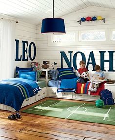 a child's bedroom with blue and white bedding, soccer themed wallpaper