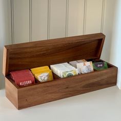 a wooden box filled with different types of chocolates on top of a white table