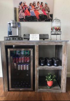 an open cabinet with drinks on it in front of a painting and coffee potted plant