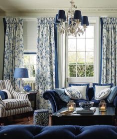 a living room with blue couches and curtains