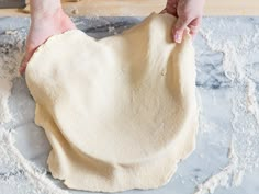 a person is kneading dough on a table