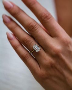 a woman's hand with a diamond ring on it