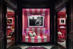 a pink and white striped couch sitting in a room next to a painting on the wall