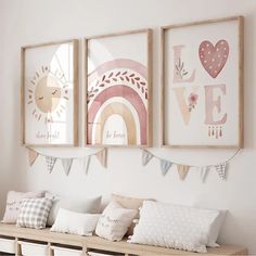 three framed pictures hang on the wall above a bench in a child's room