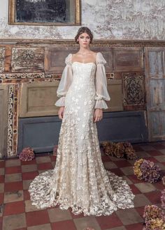 a woman standing in front of a painting wearing a wedding dress