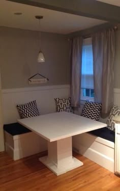 a white table and bench in a small room