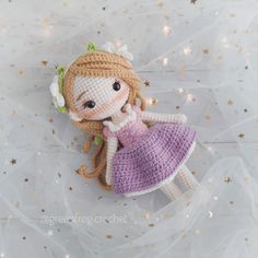 a crocheted doll laying on top of a white sheet with stars around it