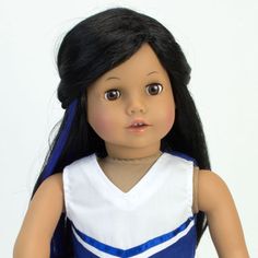 a doll with long black hair wearing a blue and white dress