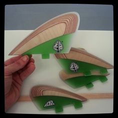 three wooden surfboards with green and white designs on them