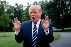 a man in a suit and tie making the vulcan sign with his hands while standing on a road