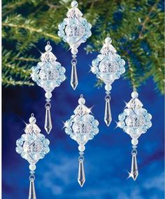 christmas ornament hanging from a tree with snowflakes and crystals on it