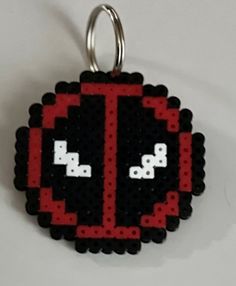 a black and red keychain with an image of the letter t on it