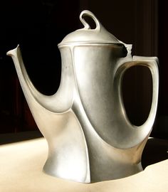 a silver tea pot sitting on top of a table