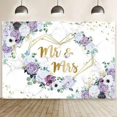 a white wall with purple flowers and the words mr and mrs in gold foil on it