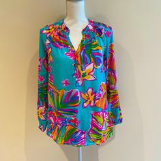 This Lilly Pulitzer Blouse Is Brand New With Tags. It Has Long Sleeves And Gold Buttons On The Front. Multicolor Long Sleeve Summer Blouse, Chic Split Neck Top For Vacation, Chic Split Neck Blouse For Vacation, Multicolor Long Sleeve Tropical Print Blouse, Summer Long Sleeve Blouse With Vibrant Print, Multicolor Long Sleeve Blouse With Tropical Print, Green Holiday Tops For Spring, Green Tops For Spring Holiday, Multicolor Printed Holiday Tops