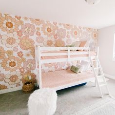 a white bunk bed sitting in a bedroom next to a flower wallpapered wall