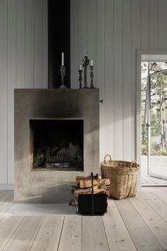 a living room with a fire place next to a basket on the floor and an open door