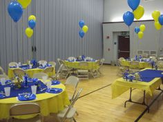 tables set up with blue and yellow tablecloths for a party or function hall