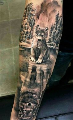 a man's arm with a wolf and cub tattoo on the left inner forearm