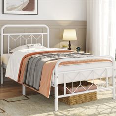 a white metal bed frame sitting on top of a rug in a bedroom next to a window