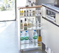 a kitchen with an oven and shelves filled with bottles