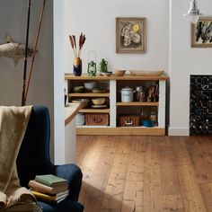 a living room filled with furniture and lots of books on top of a hard wood floor