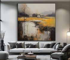 a living room filled with furniture and a large painting hanging on the wall above it