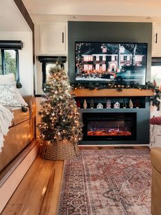 a living room with a christmas tree in the corner and a tv on top of it