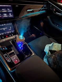 the interior of a modern car with blue lights and electronic controls on it's dashboard