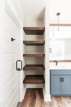 an empty kitchen with wooden shelves and blue cabinets