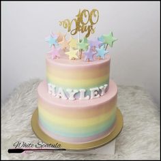 a multi - tiered cake with stars on top and the words hey written in gold