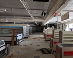 an empty office with lots of desks and shelves in the middle of the room