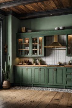 a green kitchen with wooden floors and cabinets in the corner, along with potted plants