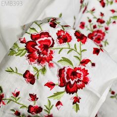 red flowers on white linens with green leaves