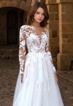 a woman wearing a white wedding dress with long sleeves