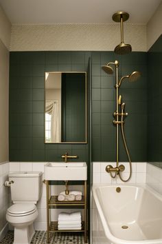 a bathroom with green and white tiles, gold fixtures and a bathtub in the corner