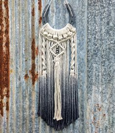 a black and white bag hanging on the side of a metal wall with rusted paint