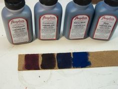 four bottles of paint sitting on top of a table