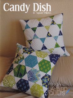 the cover of candy dish quilts is shown with two pillows on top of it