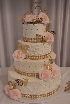 a three tiered wedding cake with pink flowers and butterflies on it's side