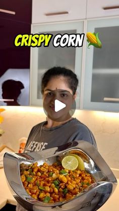 a man holding a tray filled with food in front of his face and the words crispy corn on it