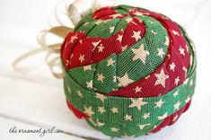 an ornament made out of fabric with stars on it and a bow hanging from the top